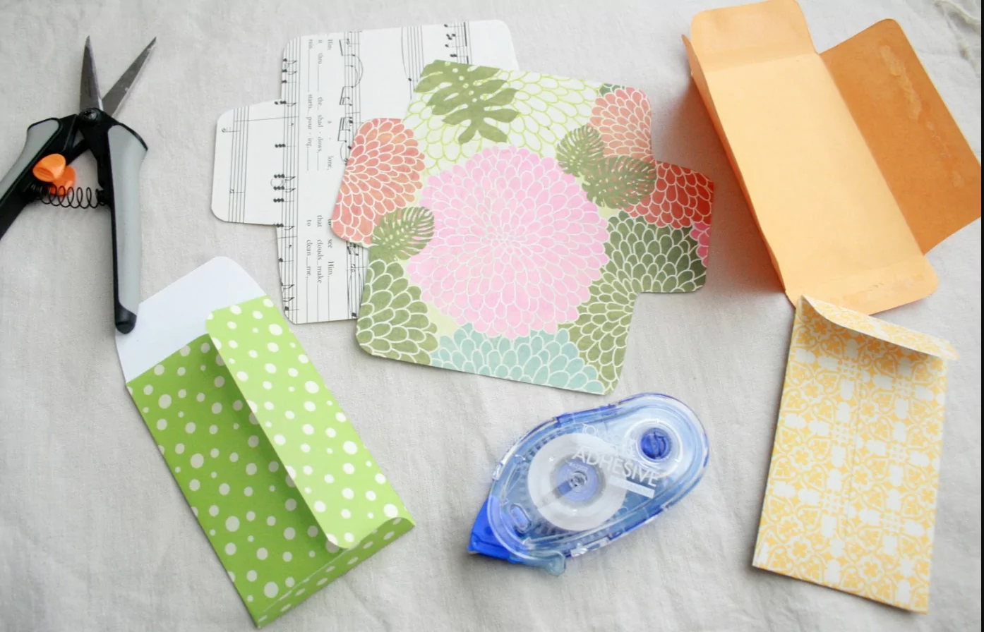 Hands placing small DIY paper envelopes numbered 1 to 24 into a decorative wooden box